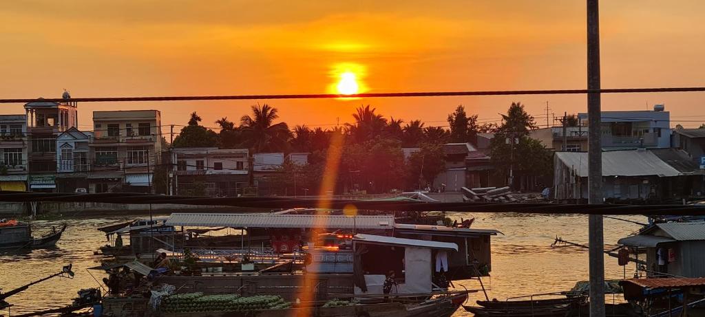 einen Sonnenuntergang über einem Hafen mit Booten im Wasser in der Unterkunft Grandma House in Cần Thơ