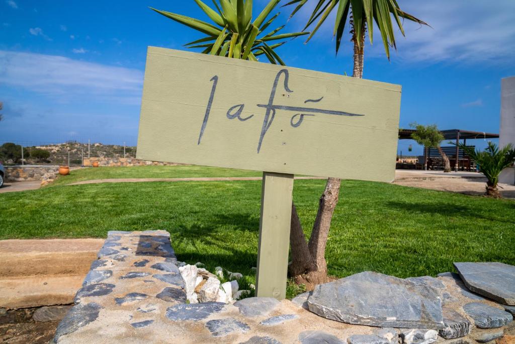 a sign with writing on it in a park at Lafo Rooms in Elafonisi