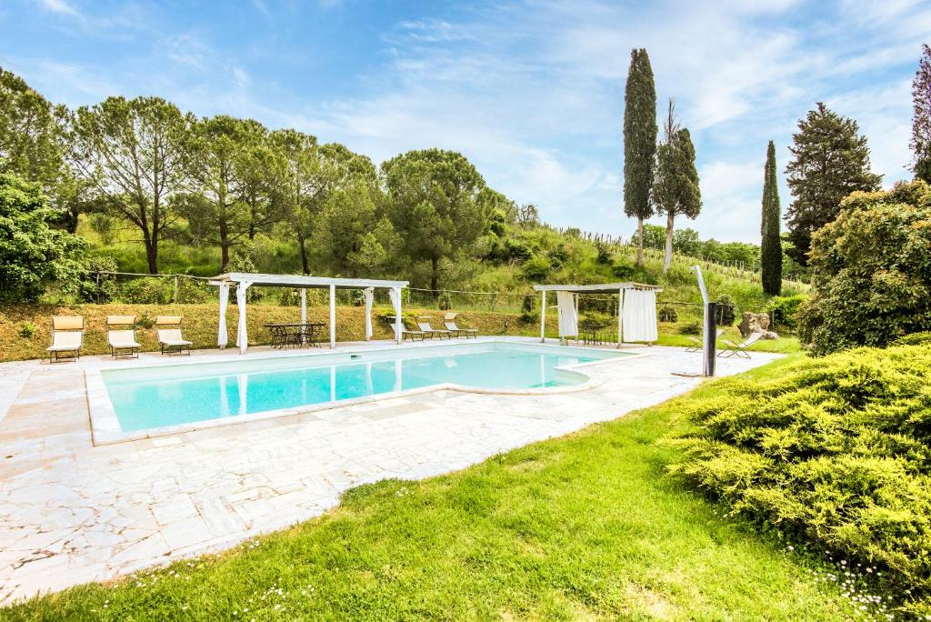 een zwembad in een tuin met een grasveld bij Villa Il Fornacino in Rapolano Terme