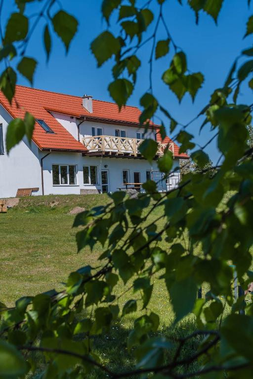 a house with an orange roof on a hill at Siedlisko Pili Pili in Sorkwity