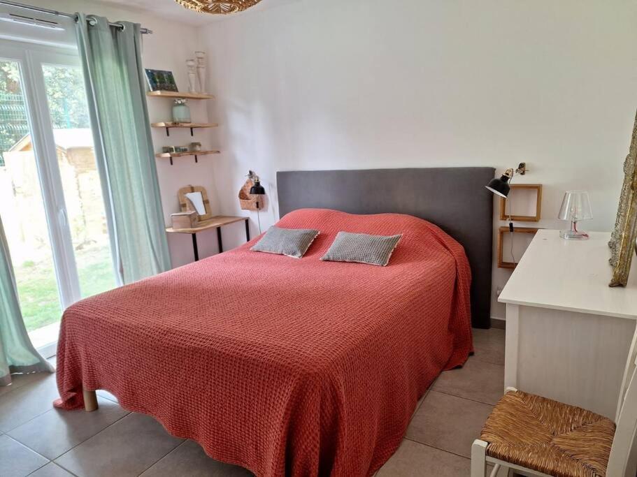 - une chambre avec un lit rouge et une couverture rouge dans l'établissement Appartement douillet avec jardin pour 4 personnes, à Cauro
