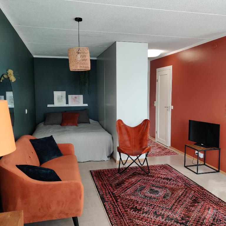 uma sala de estar com um sofá e uma cama em Sataman helmi em Savonlinna