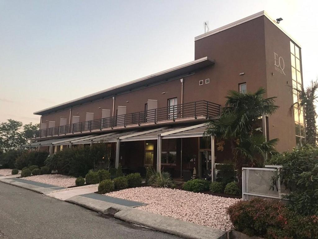 a building with a balcony on the side of it at eq hotel in Travagliato