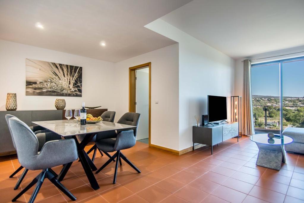 a dining room and living room with a table and chairs at Swiss Green Appartement Cosy et Spacieux in Quarteira