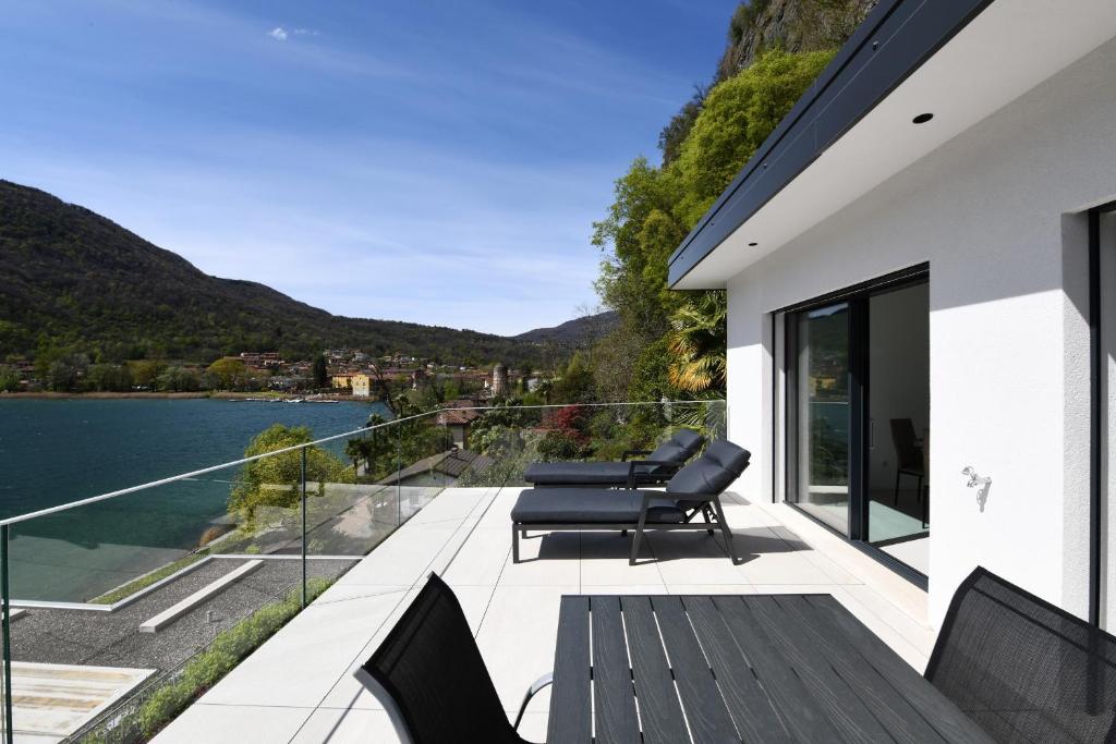 a balcony with chairs and a view of the water at Sans Souci 2 in Caslano