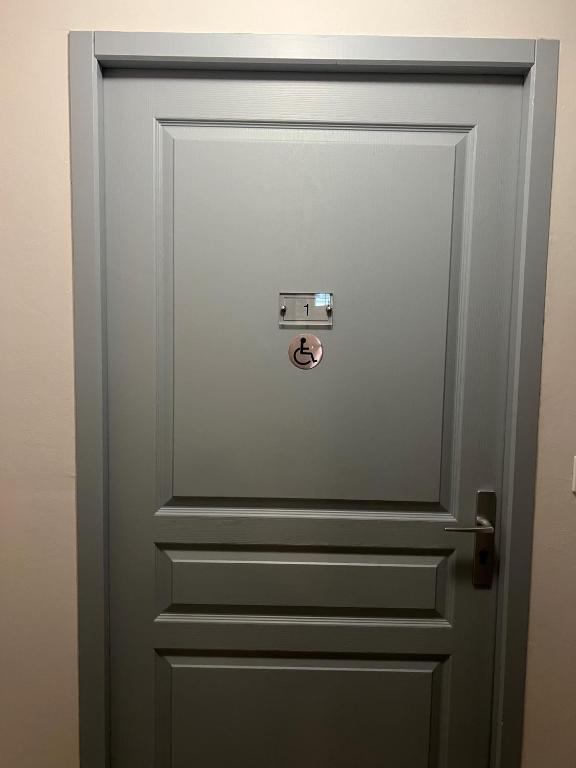 a grey door with a knob on it at Hôtel de Lion sur Mer in Lion-sur-Mer
