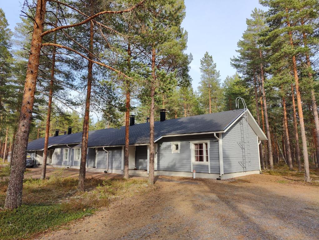 a white house with a gambrel roof in the woods at Nicolas apartment in Loimaa