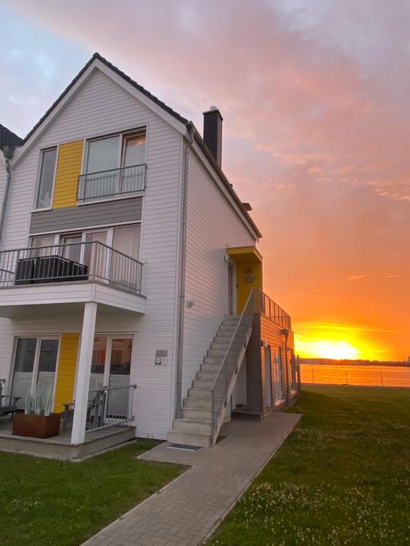 オルペニッツにあるPierhaus 14の夕日を背景に見える白い家
