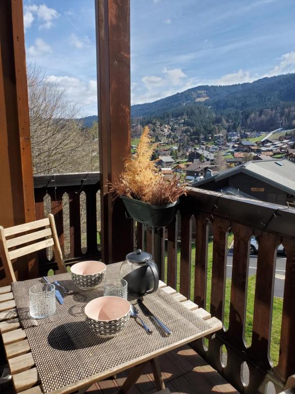 une table sur un balcon avec vue sur une ville dans l'établissement Studio avec petit balcon et cheminée - Grand Massif, aux Carroz d'Arâches