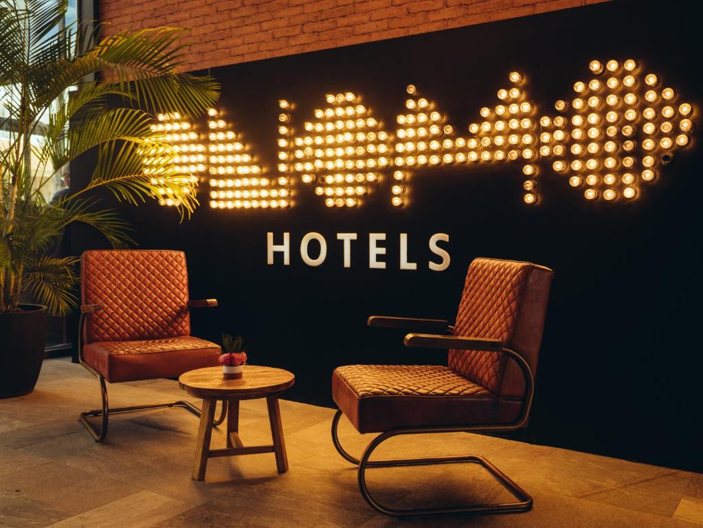 ONOMO Hotel Casablanca Sidi Maarouf في الدار البيضاء: كرسيين وطاولة وعلامة مكتوب عليها الفندق