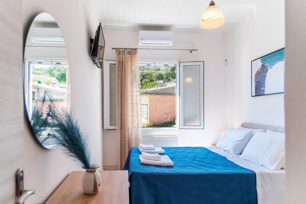 a bedroom with a bed with blue sheets and a window at Antiopi's Vacation House in Argyrádes