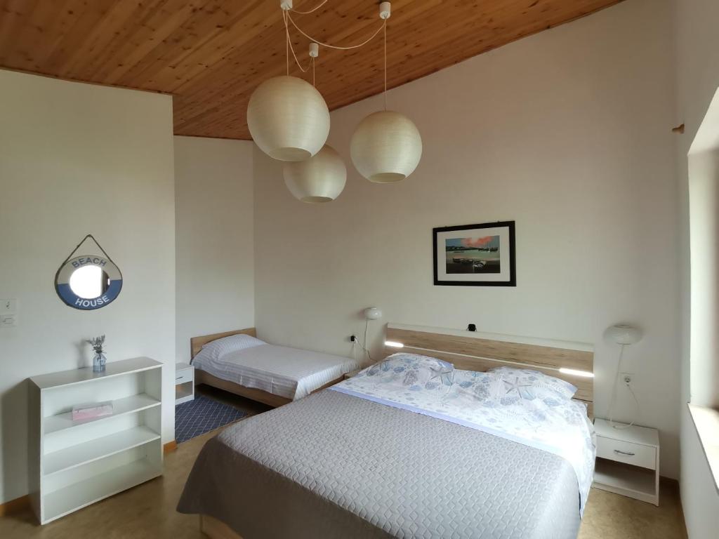 a white bedroom with a bed and two lamps at Apartment Studio Zvonka in Zambratija