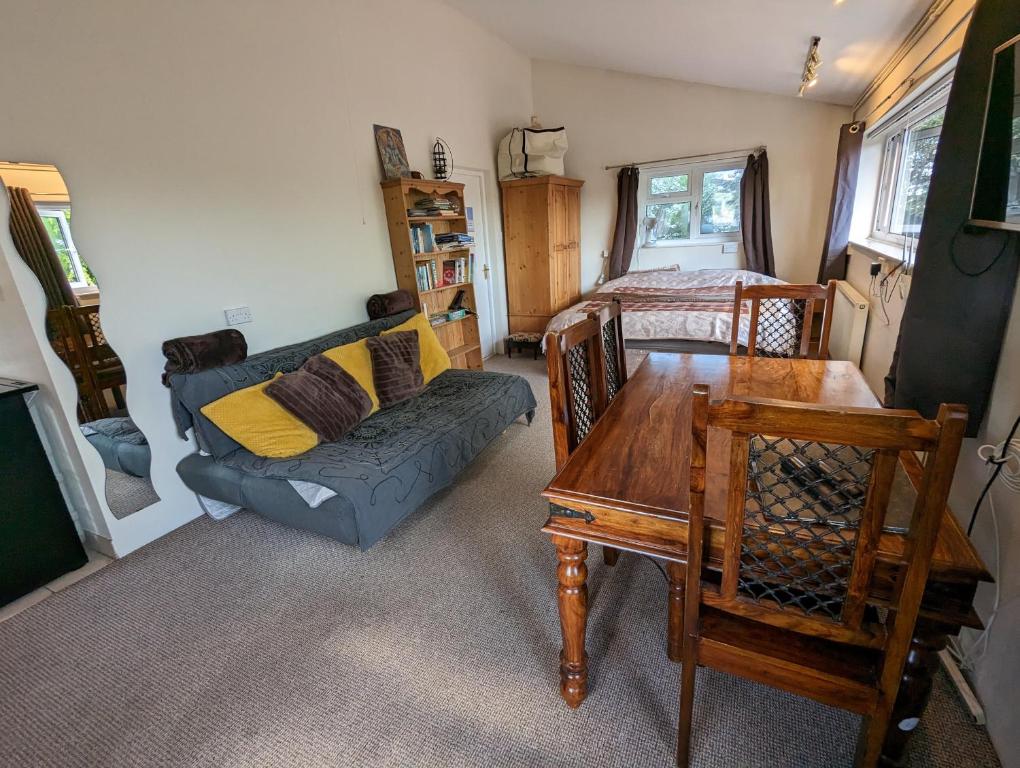 a living room with a couch and a table at Bristol self-catering studio+kitchen+parking in Bristol