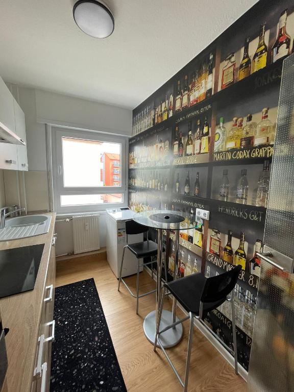 eine Küche mit einer Bar mit einem Tisch und Stühlen in der Unterkunft Joanna Apartment - MA Käfertal 1 in Mannheim