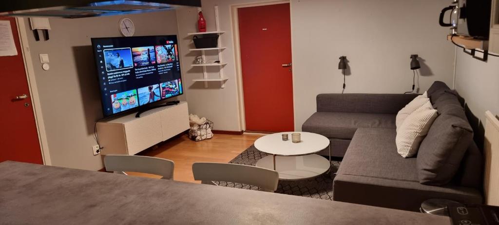 a living room with a couch and a flat screen tv at 4-bäddsrum Hultsfred in Hultsfred