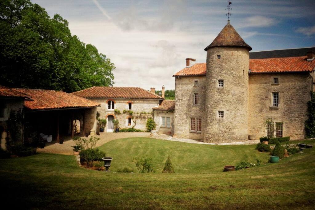 a large stone building with a tower in a yard at Charmante Demeure 17ème 4ch-3sdb in Bioussac