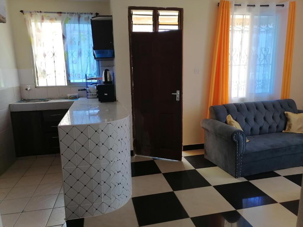 sala de estar con sofá y cocina en La Grande 1bedroom Apartment Mtwapa, en Mtwapa