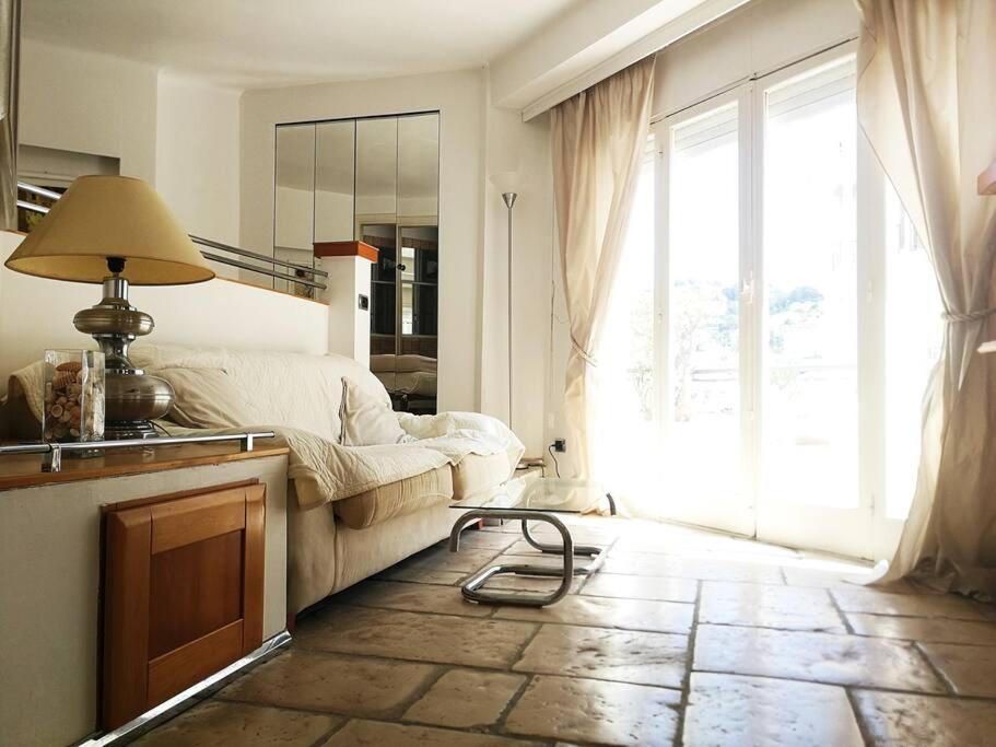 een woonkamer met een bank en een groot raam bij Open space with sea view close to the Croisette in Cannes