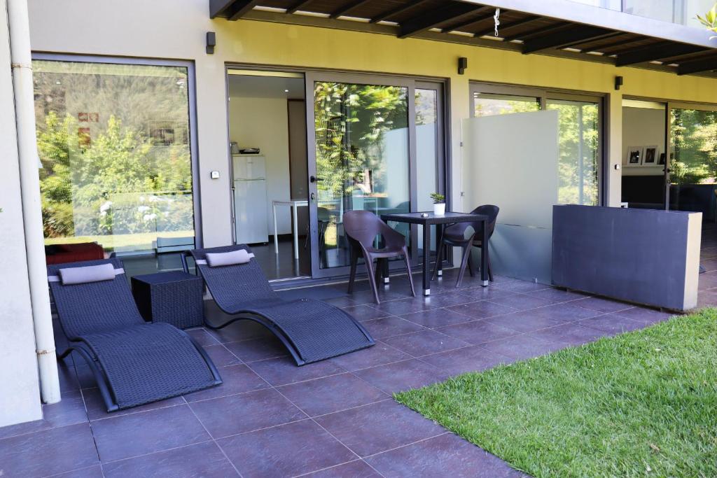 patio con sedie, tavolo e finestre di Apartamento Esquilo - Casas Barca do Rio - Gerês a Geres