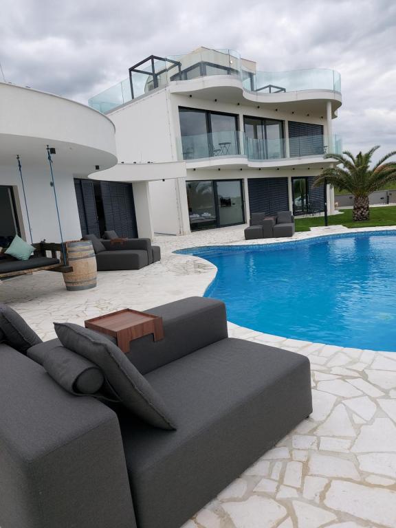 una casa grande con piscina frente a ella en The ViewBay, en Privlaka
