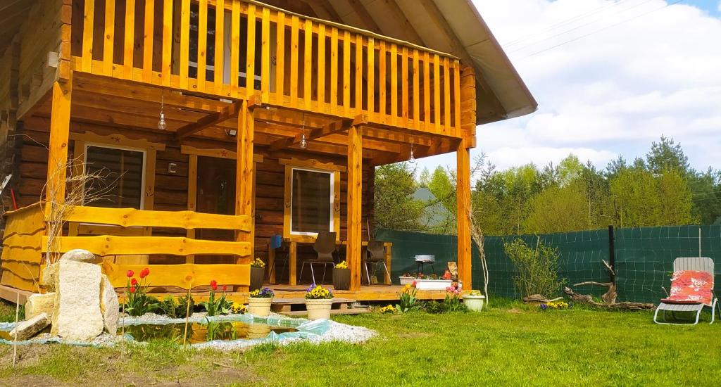 a tiny house with a large deck in a yard at Zagroda Podlas - gospodarstwo agroturystyczne 2 in Aleksandrów