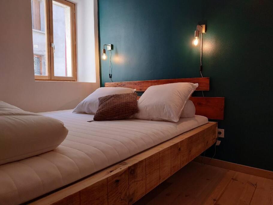sypialnia z drewnianym łóżkiem z 2 poduszkami w obiekcie Chamalières Sur Loire : Un superbe appartement w mieście Chamalières-sur-Loire