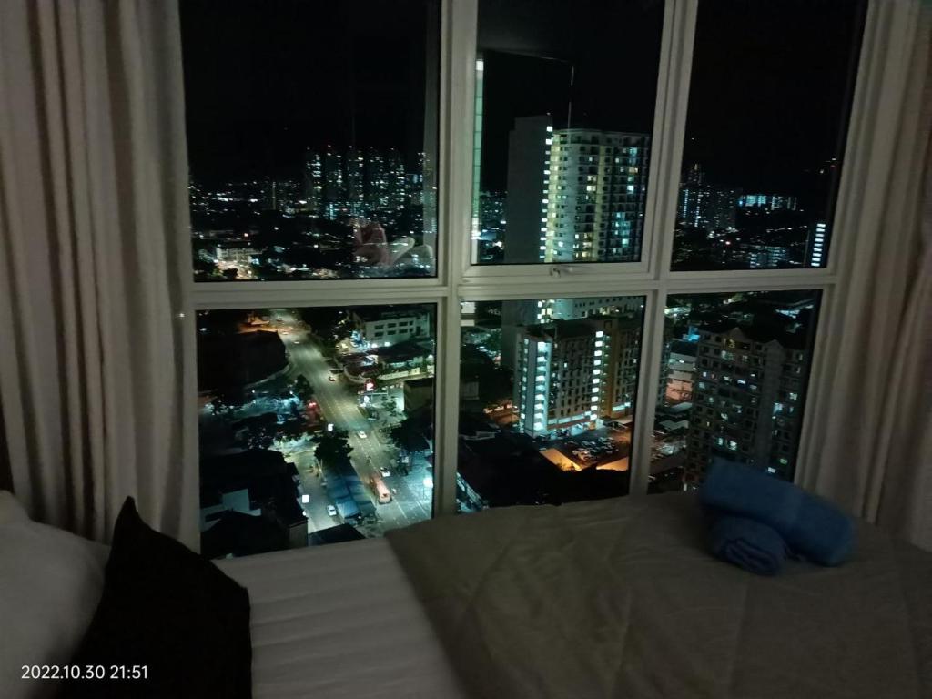 - une fenêtre avec vue sur la ville la nuit dans l'établissement City Town 2-6 Pax Beautiful View Cozy Condo, Jelutong, Georgetown, Centre Heart Of Penang Island, near Highway Komtar Gurney, à George Town