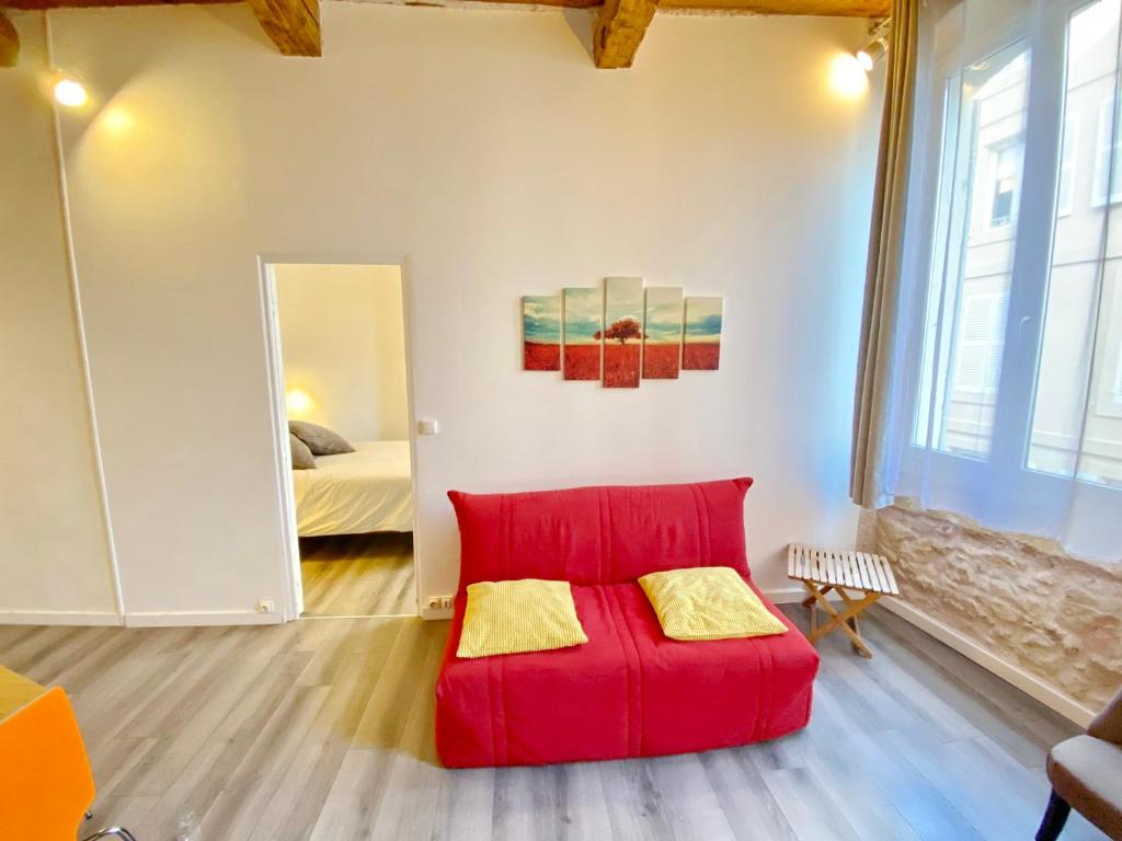 a red couch in a room with a bedroom at Vieux Port Proximité Panier Clim Central Cachet in Marseille