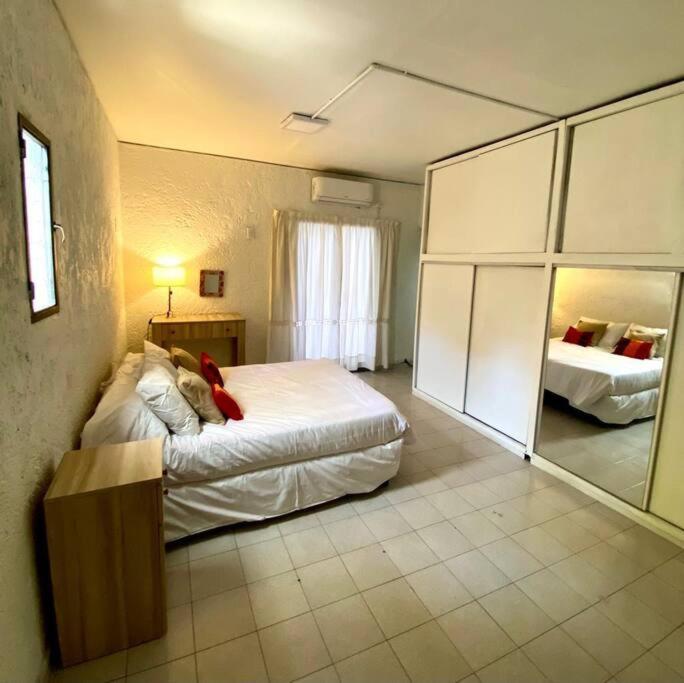 a bedroom with a large bed and a mirror at Duplex con terraza y estacionamiento p auto! in Mendoza