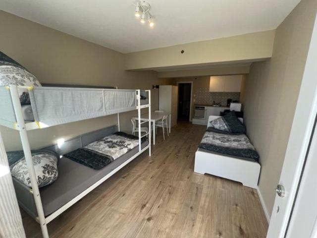 une chambre avec deux lits superposés et une cuisine dans l'établissement Malibu Monteur Apartment, à Rodenbach