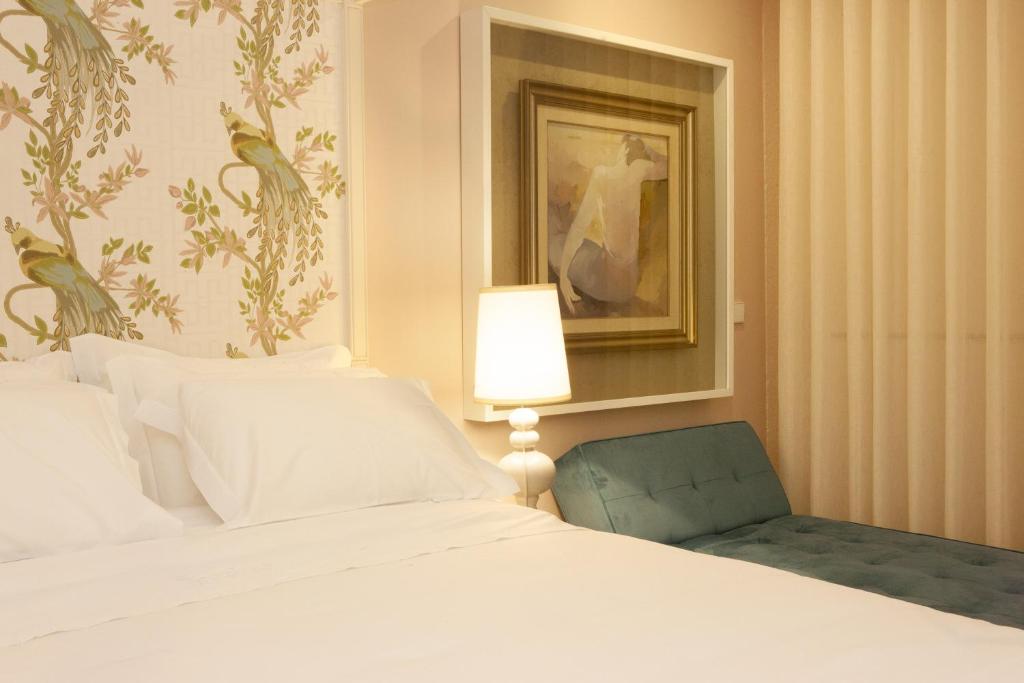 - une chambre avec un lit, une lampe et une chaise dans l'établissement In Porto Gallery Guesthouse, à Porto