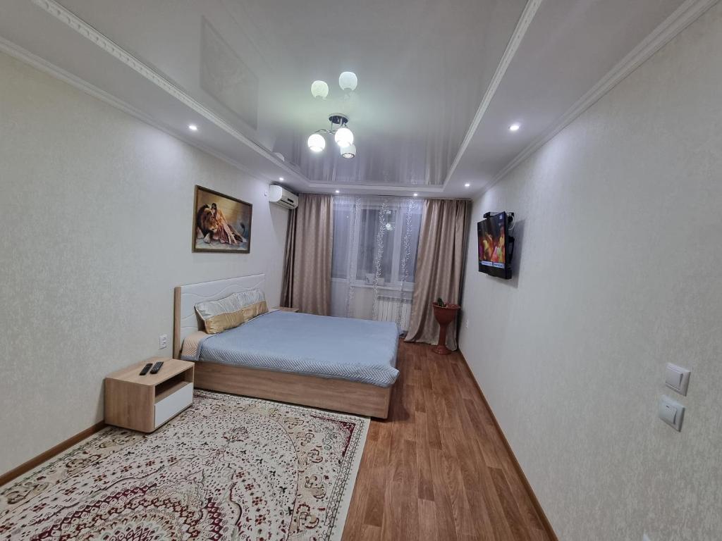 Dormitorio pequeño con cama y alfombra en Посуточная квартира на Курмангазы c Wi-Fi en Uralsk