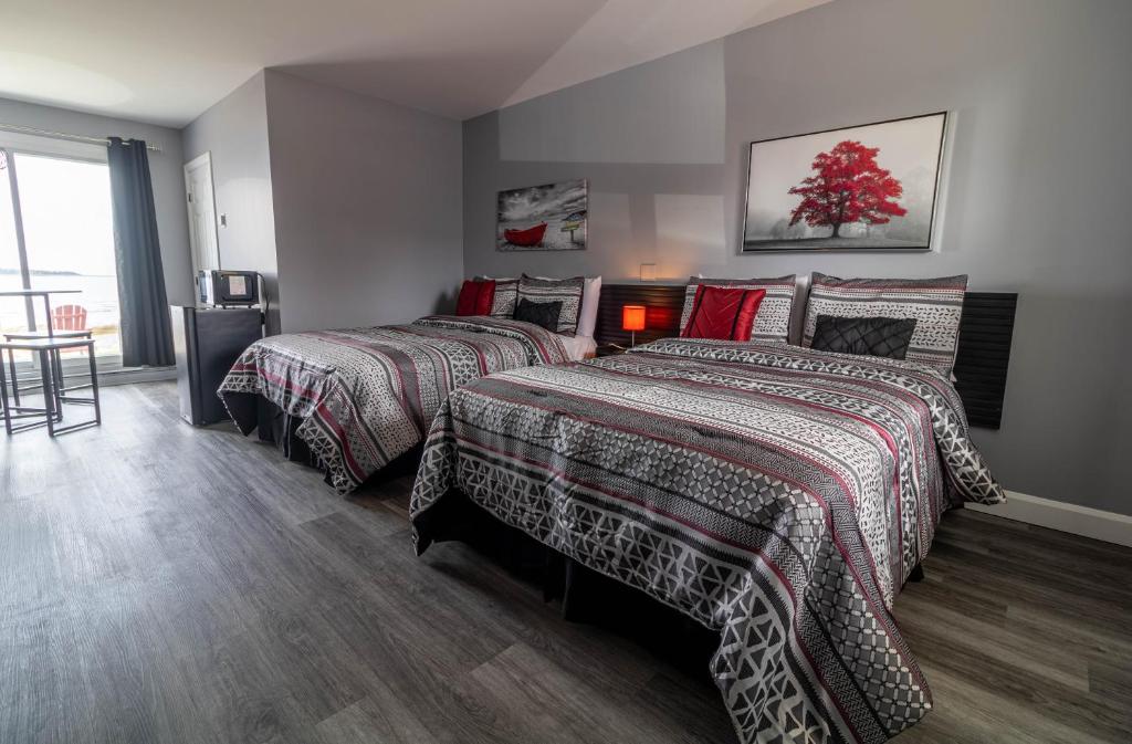 a bedroom with two beds and a table at Motel Rimouski in Rimouski