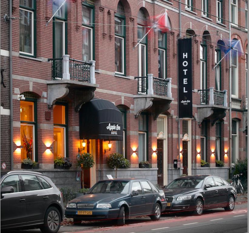 drie auto's geparkeerd voor een bakstenen gebouw bij Apple Inn Hotel in Amsterdam