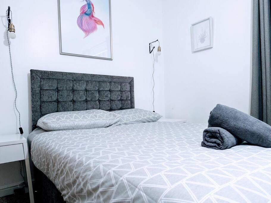 a bedroom with a bed with a white bedspread at City Centre Comfort Northampton in Northampton