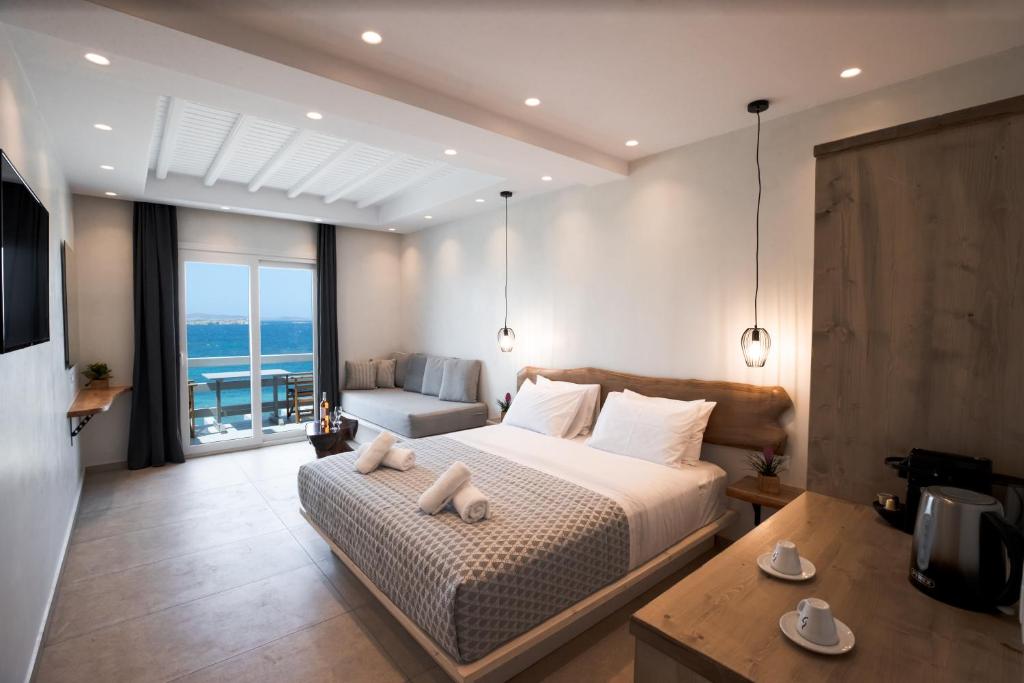 a bedroom with a bed and a view of the ocean at Magic View Suites Mykonos in Mikonos