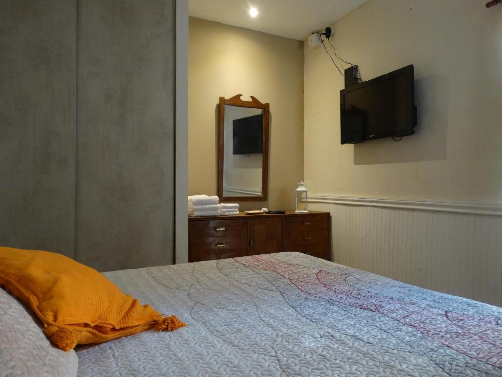 a bedroom with a bed and a tv on the wall at Departamento Benissa en San Juan in San Juan