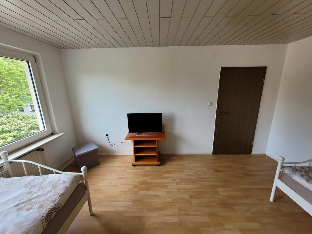 1 dormitorio con 1 cama y mesa con TV en BK Meiderich, en Duisburg