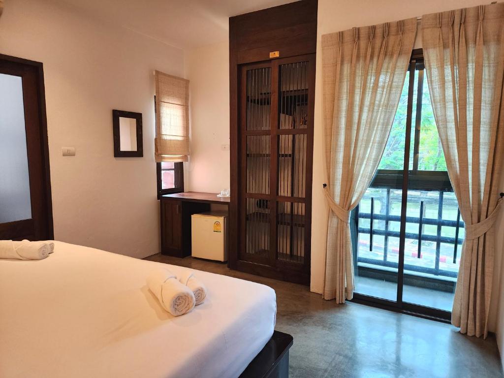 A double bedroom opens onto a curtained balcony or exterior window.