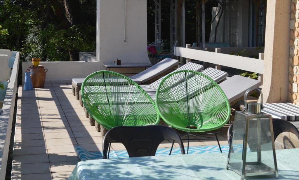 two green chairs and a table on a patio at Casa mARTa : Suites, terrasses et vue panoramique in Tournon-sur-Rhône