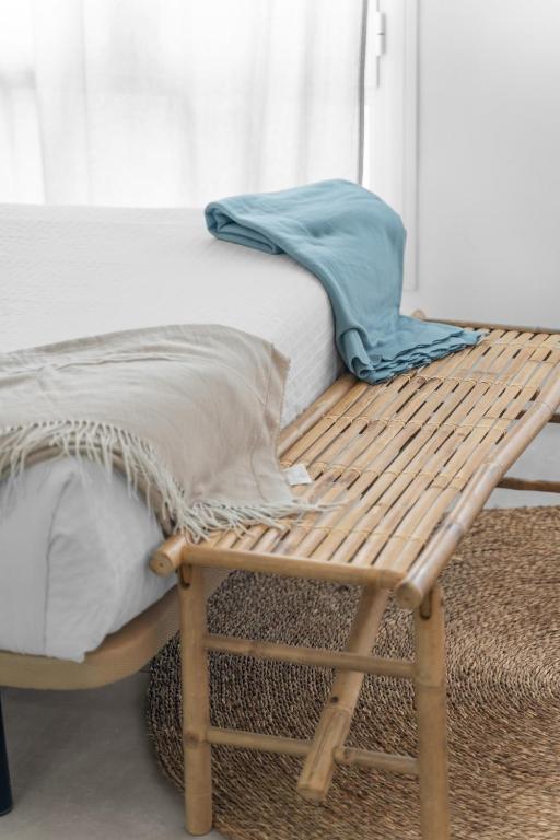 a wooden bench sitting next to a bed at Apartamentos GAV in Ronda