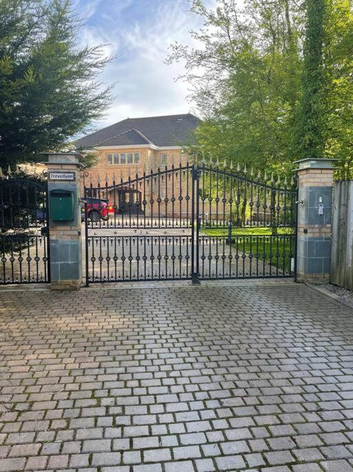 a black iron gate with a brick walkway in front at Luxury Studio Loft with Car Charging Point in Frizington