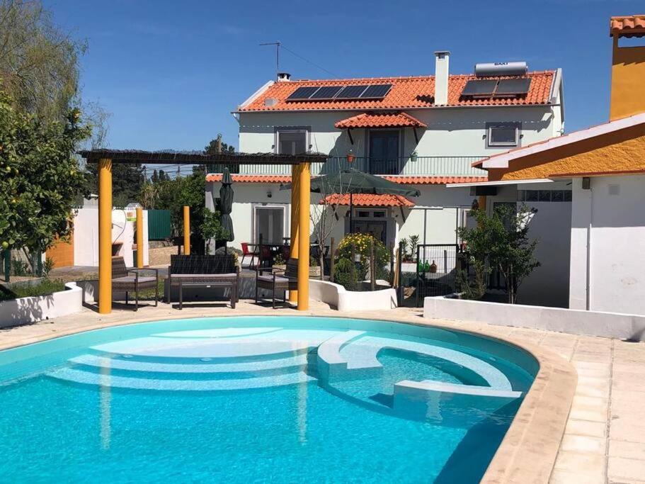 une grande piscine bleue en face d'un bâtiment dans l'établissement Casa Almenara, à Quinta do Anjo