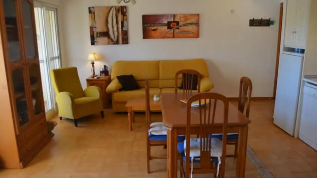 sala de estar con sofá, mesa y sillas en Felicidad en Denia