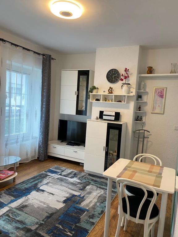 uma sala de estar com uma mesa e uma cozinha em Modernes Studio em Baden-Baden