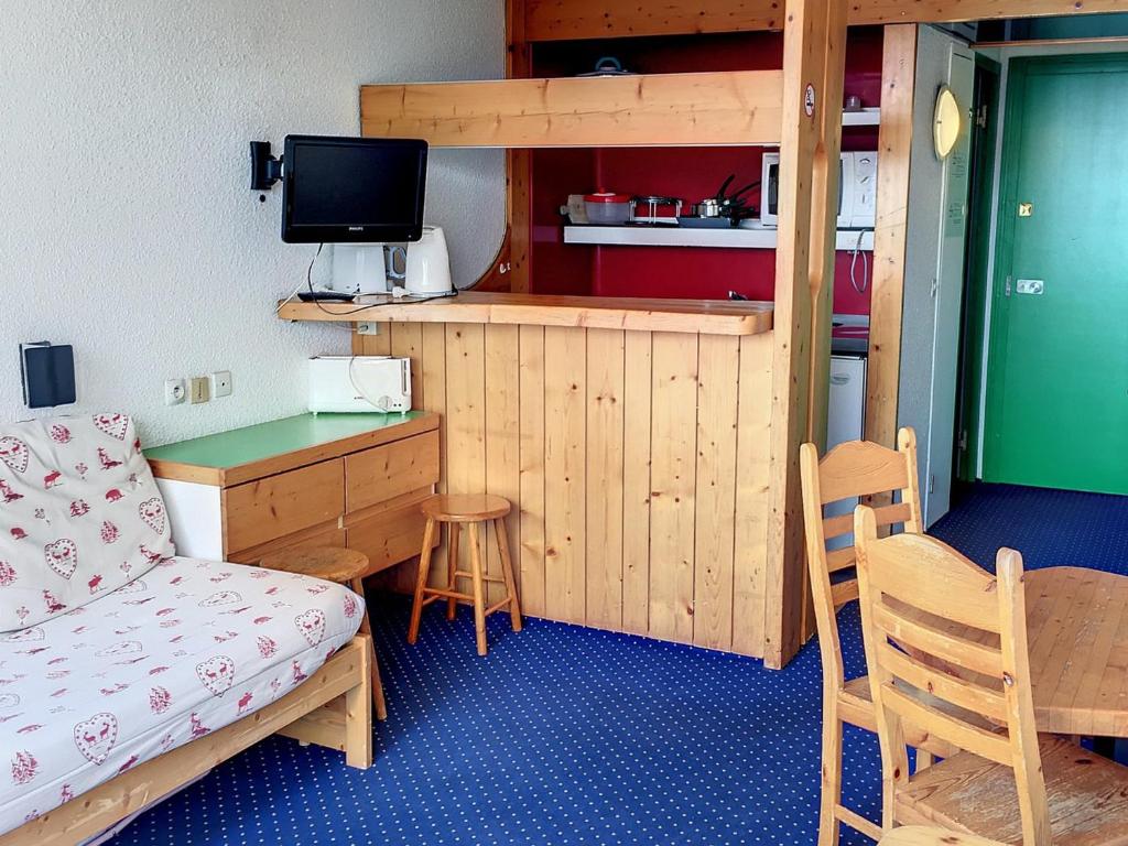 Cette petite chambre comprend un lit, un bureau et une télévision. dans l'établissement Appartement Ski aux Pieds · Balcon Sud/Ouest · Wifi Gratuit · Arc 1800 - FR-1-346-479, à Arc 1800