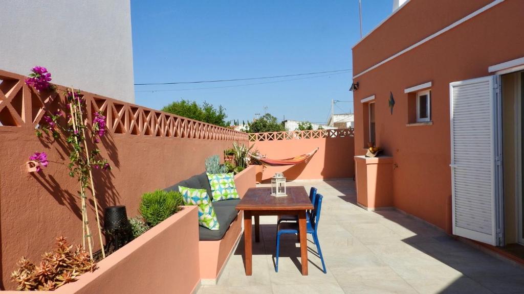 patio con mesa y sillas en el balcón en Casa Limão, en Azinhal