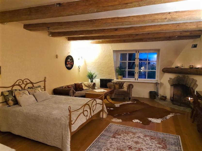 una camera con letto e un soggiorno con camino di Cozy Old Town Historic House a Tallinn