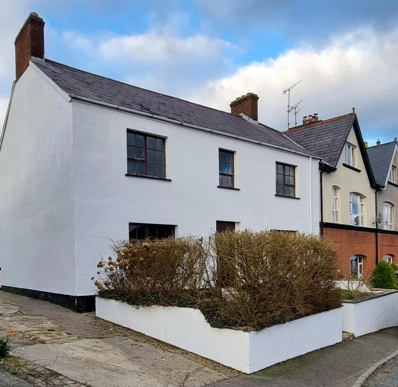 ein weißes Haus mit schwarzen Fenstern auf einer Straße in der Unterkunft Brookmount House in Omagh