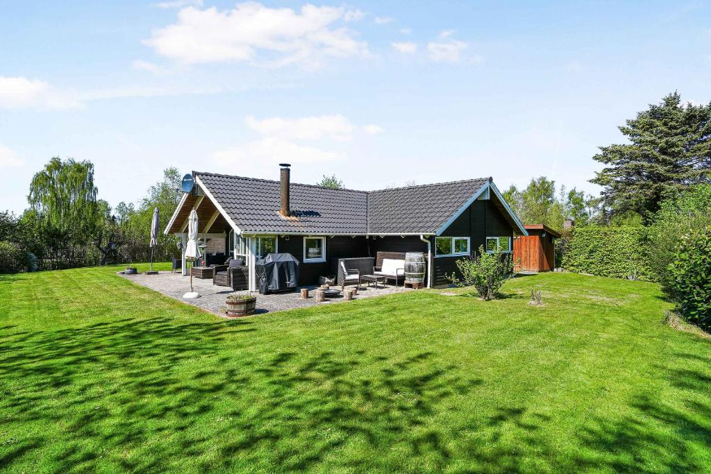 uma casa com um relvado verde em frente em Beautiful Holiday Home In North Zealand em Tikøb